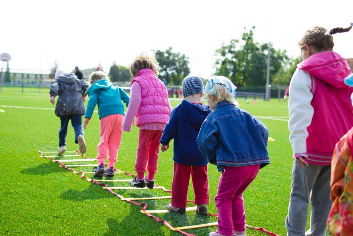 Kinder beim Sport auf Rasen. Quelle: pexels.com