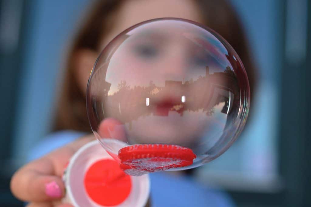 Mädchengesicht durch Seifenblase hindurch fotografiert