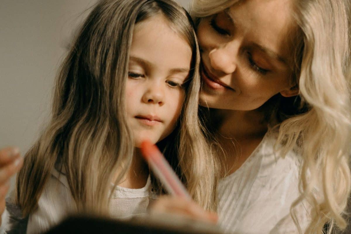 Mutter mit Tochter, die etwas schreibt. Quelle: pexels.com